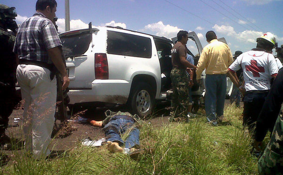 The body of a victim lies at the side of the road after a Mexican navy vice admiral was ambushed in his SUV in Michoacan state on July 28.