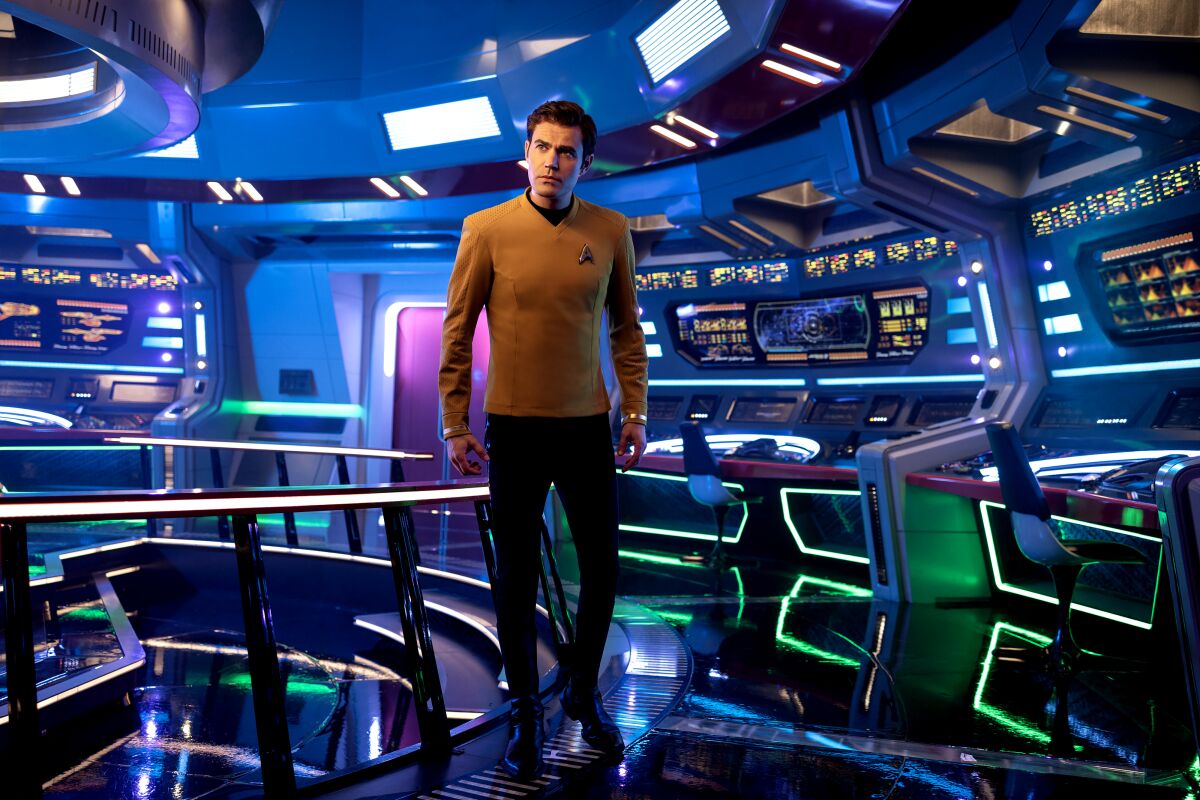 James T. Kirk walks by a railing on a space ship.