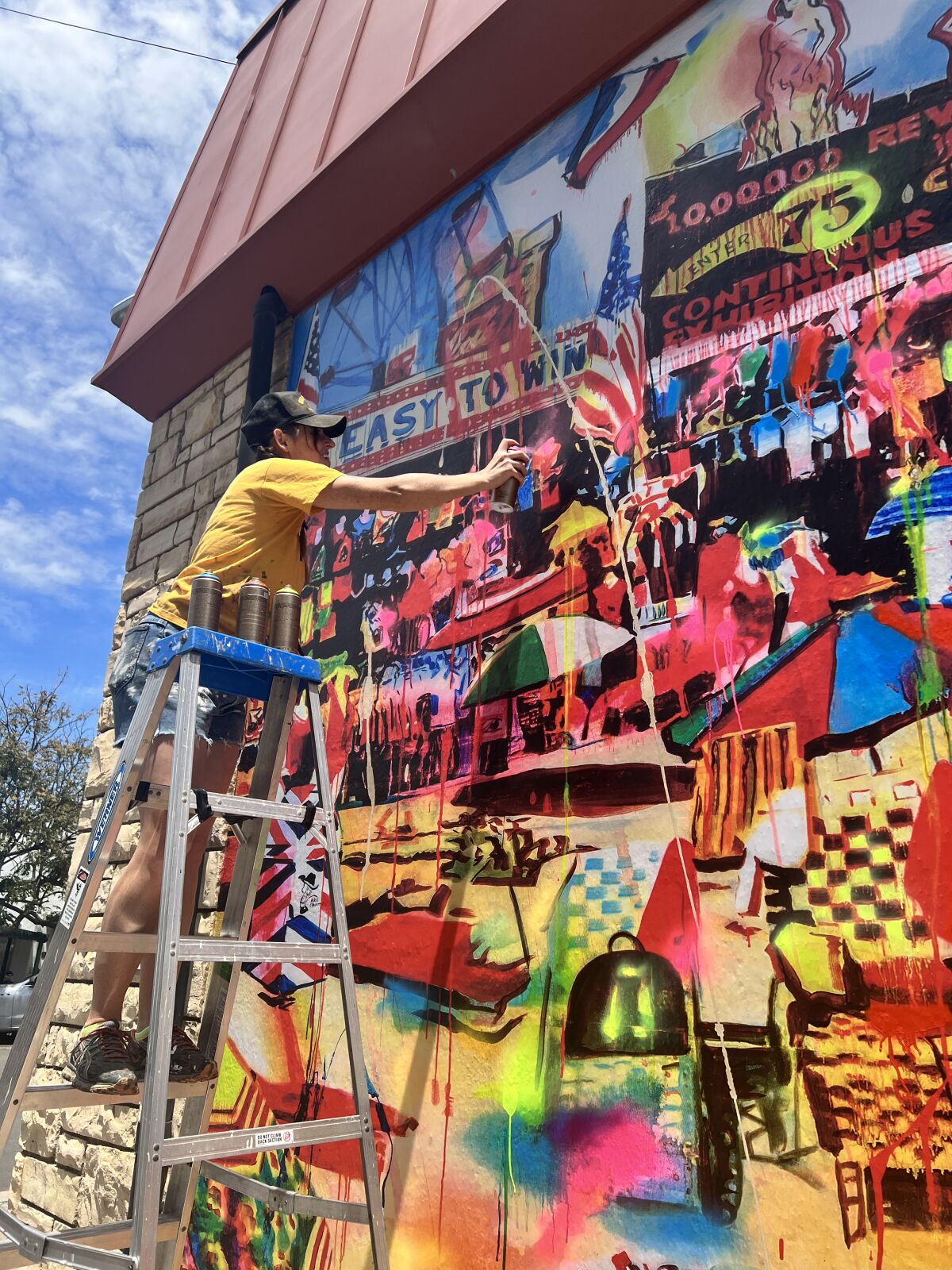 Artist Rosson Crow returned to her mural “Ocean Front Property in Arizona” on May 14 to add spray-painted and enamel colors.