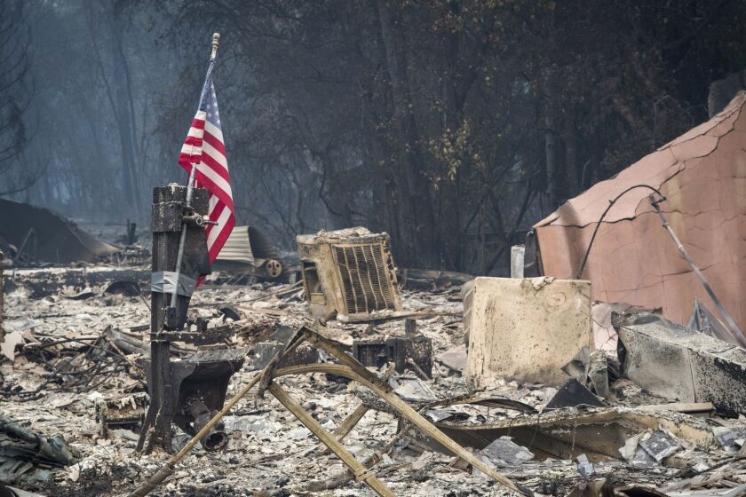 An American flag stands among burned rubble during the Camp Fire in Paradise, California on Nov. 13. MUST CREDIT: Bloomberg photo by David Paul Morris. ** Usable by LA, BS, CT, DP, FL, HC, MC, OS, SD, CGT and CCT **