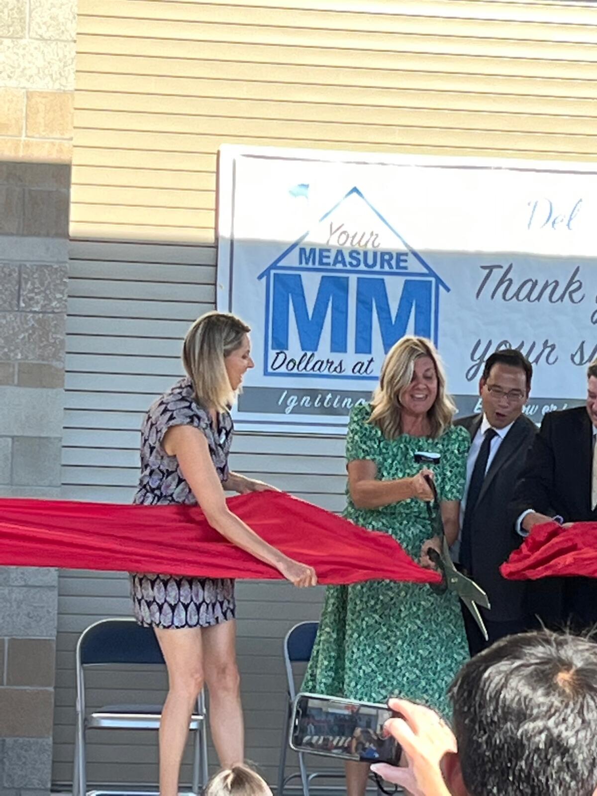 DMUSD Trustees Katherine Fitzpatrick and Gee Wah Mok help Pacific Sky Principal Alison Fieberg with the ribbon cutting.