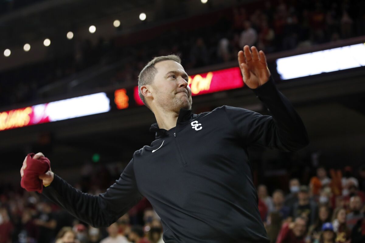USC football coach Lincoln Riley throws a T-shirt to a fan during a basketball game Dec. 12
