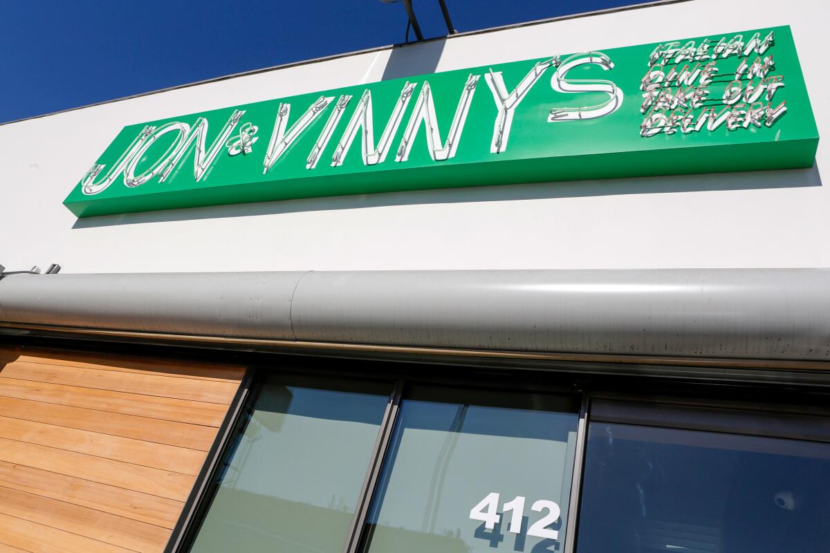 Exterior of restaurant with green sign reading "jon and vinny's"