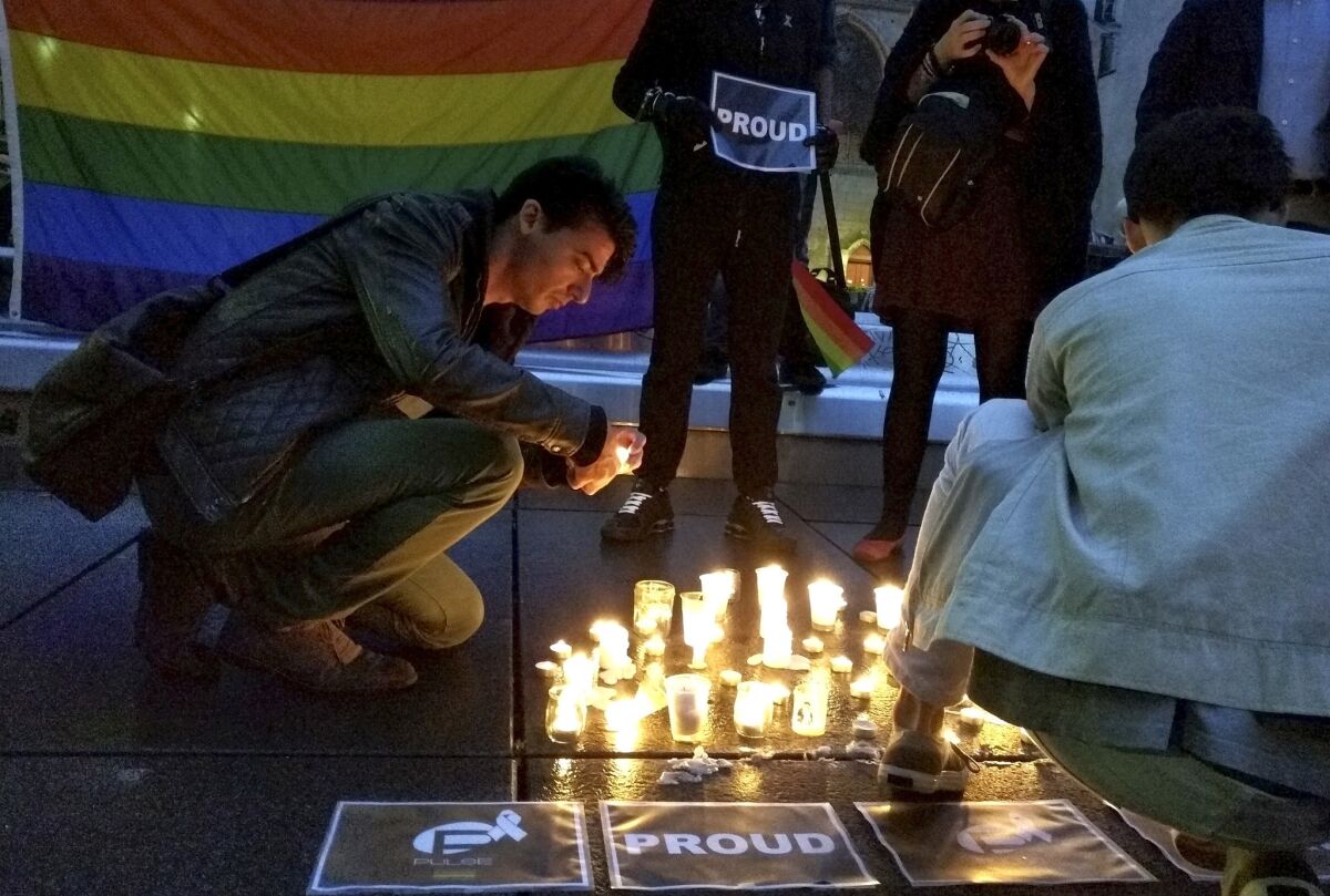 A man lights a candle in Paris on June 12 to remember those slain and wounded in the Orlando nightclub shooting.