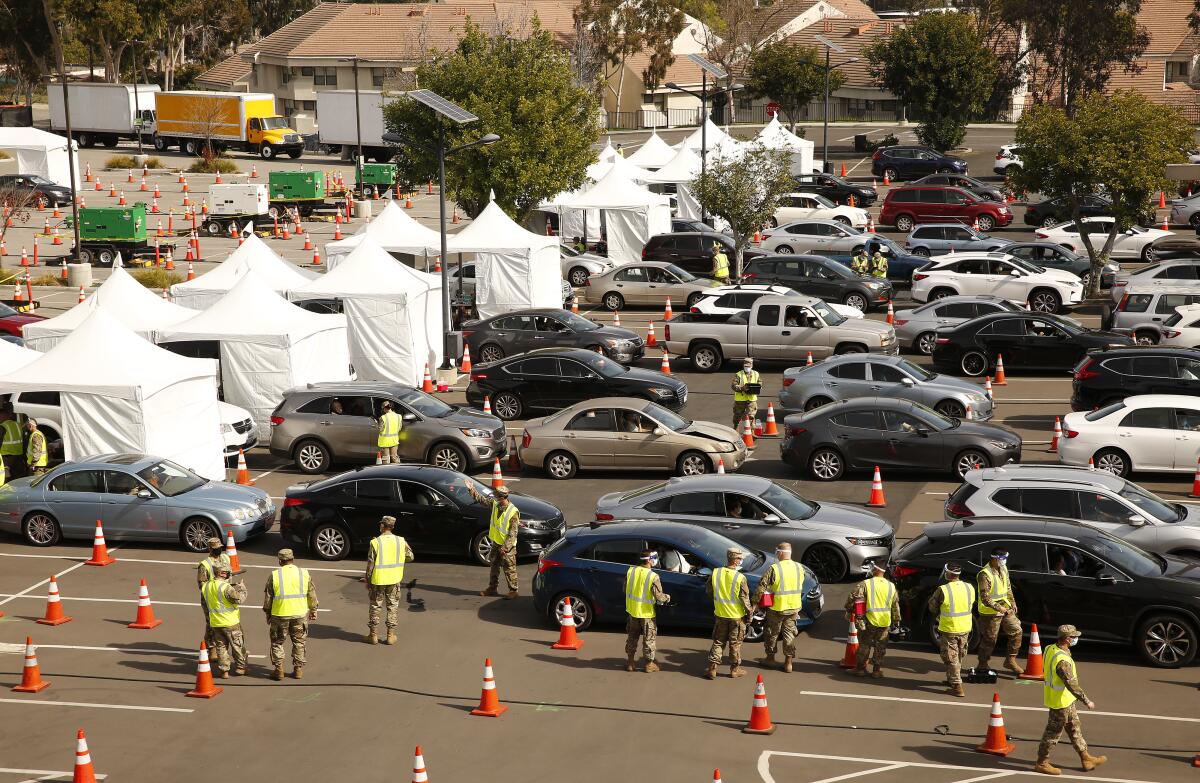 Vehicles line up at a COVID-19 vaccination site at Cal State Los Angeles. 