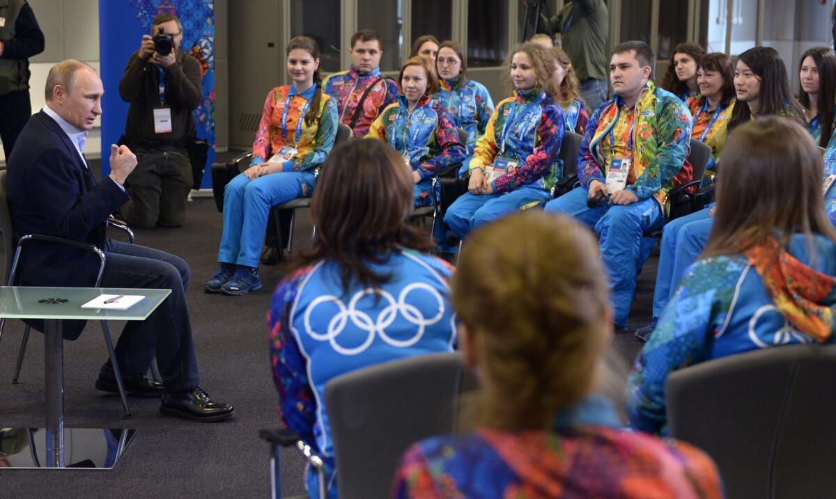 Russian President Vladimir Putin, left, speaks Friday at his meeting with Olympic volunteers in the Black Sea resort of Sochi, Russia. Putin says gay people should feel welcome at the upcoming Winter Olympic Games in Sochi, but they must "leave children in peace."