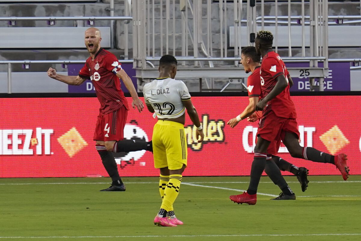Toronto FC midfielder Michael Bradley (4) celebrates with teammates after scoring a goal against the Columbus Crew as Columbus Crew midfielder Luis Diaz (12) walks away during the first half of an MLS soccer match, Wednesday, May 12, 2021, in Orlando, Fla. (AP Photo/John Raoux)