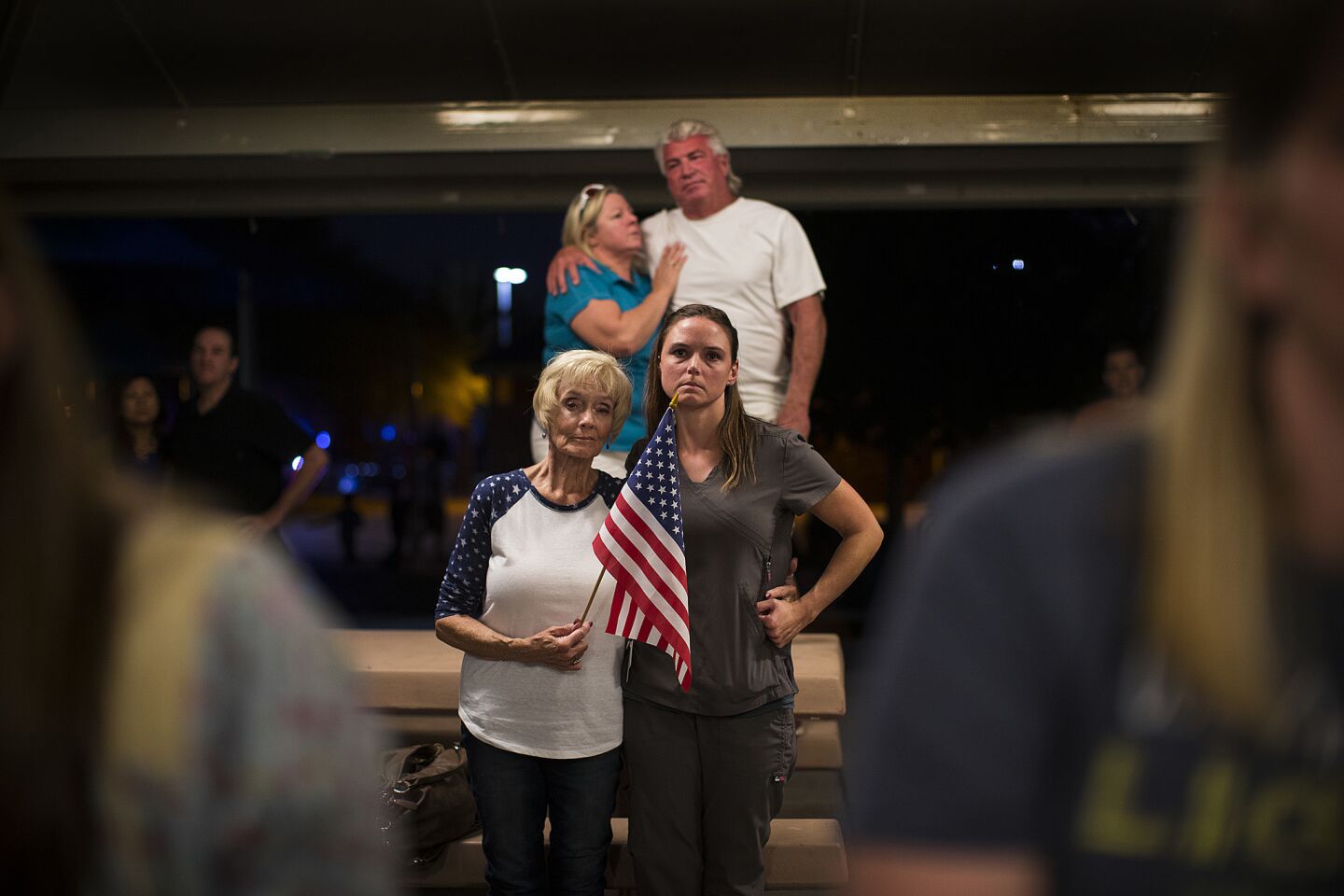 Connie Lane of Las Vegas holds an American flag with daughter Celestial Olave during a prayer vigil at Mountain Crest Park in Las Vegas.