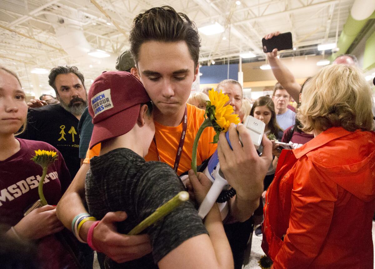 Douglas High School students David Hogg, center, and Caspen Becher, hug after an anti-school violence demonstration.