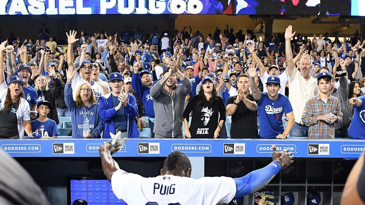 Dodgers outfielder Yasiel Puig celebrates with fans after his game-winning hit against the White Sox at Dodger Stadium Wednesday.