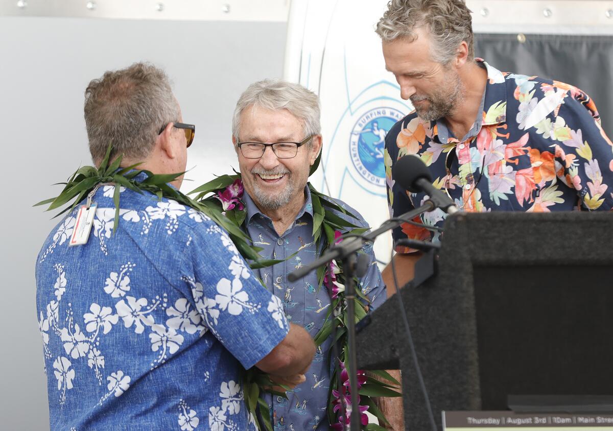 Don Hansen, center, greets event emcee Peter "PT" Townend, left, during the Surfing Walk of Fame induction ceremony.