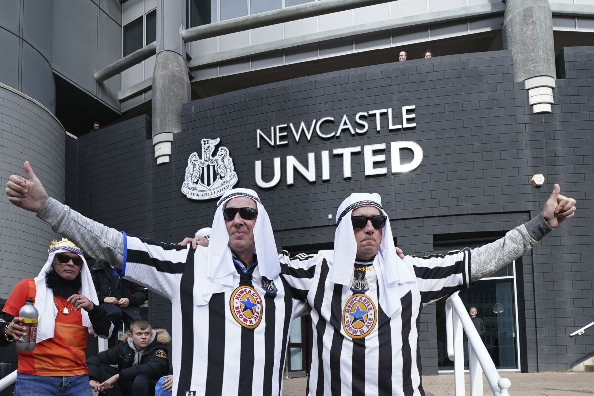 Newcastle fans pose for a photo outside the ground before an English Premier League soccer match between Newcastle and Tottenham Hotspur at St. James' Park in Newcastle, England, Sunday Oct. 17, 2021. Newcastle plays its first game under new ownership after the club was bought out last week by Saudi Arabia's sovereign wealth fund. (AP Photo/Jon Super)