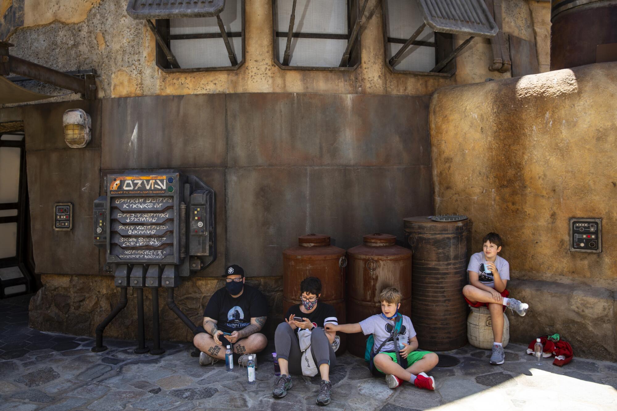 Four family members relax in the shade at Galaxy's Edge