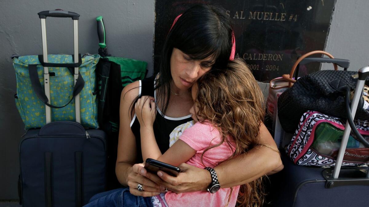 After eight hours in line, Solymar Duprey, 47, holds her daughter Miabella Lawston, 5, as they try to get on an evacuation cruise ship leaving San Juan.