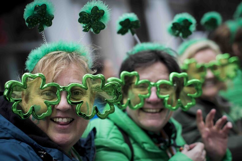 FILE - This file photo from Saturday March 16, 2019, shows Sharon Keely, left, of Dublin, viewing the St. Patrick's Day Parade along Fifth Avenue in New York. A largely virtual St. Patrick's Day is planned for New York City on Wednesday, March 17, 2021, one year after the annual parade celebrating Irish heritage became one of the city's first coronavirus casualties. (AP Photo/Mary Altaffer, File)