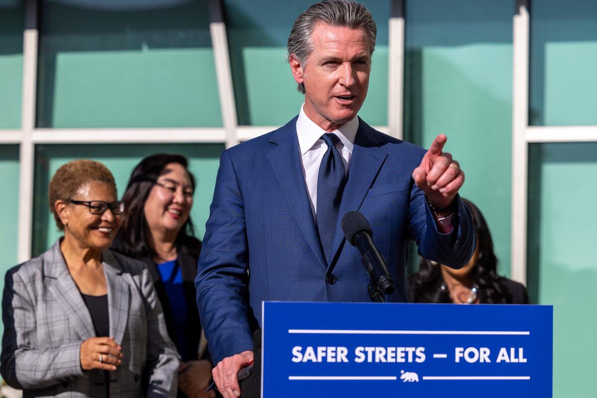 Gavin Newsom speaks at a lectern labeled "Safer Streets For All."