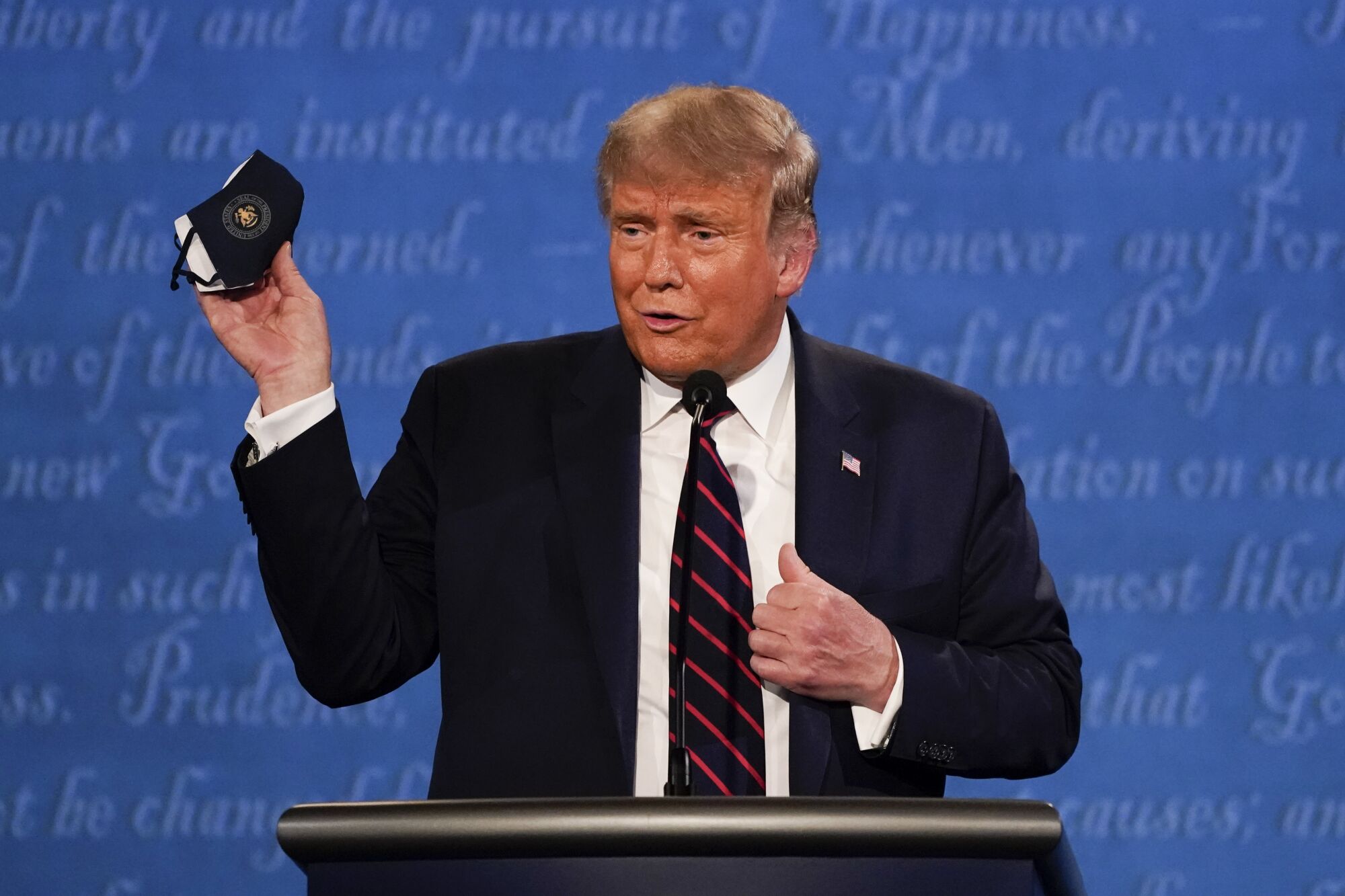 President Trump holds up his face mask during Tuesday's debate in Cleveland