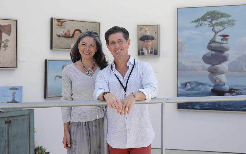 Fine artist Paul Bond, whose medium is oil paints, stands with his wife Donna as they welcome guests to their display.