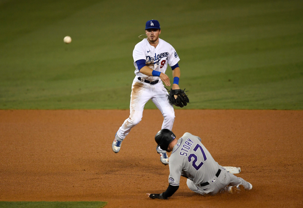 Dodgers second baseman Gavin Lux avoids a sliding Trevor Story as he throws to first base Sept. 4, 2020.