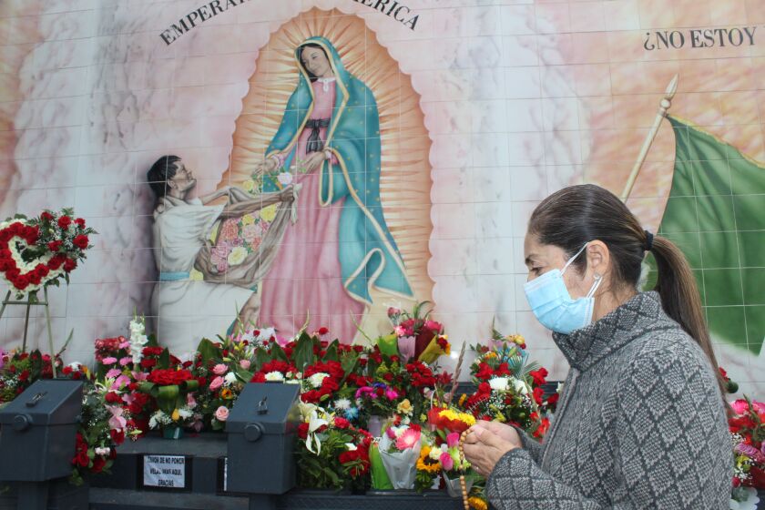 Rosalía González prays for those affected by COVID-19 at Olvera Street.