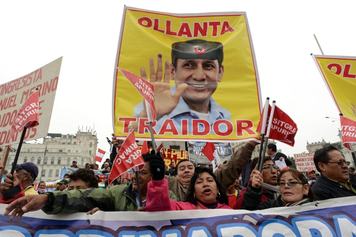 Demonstrators hold a banner saying, "Ollanta betrayer," as they protest against Peru's government at San Martin square in Lima.