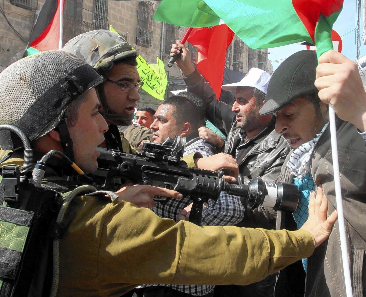 Israeli soldiers scuffle with a Palestinian demonstrator in the West Bank city of Hebron during a recent rally against the closure of Shuhada Street and to mark the anniversary of the 1994 massacre of 29 Palestinians by a Jewish settler.
