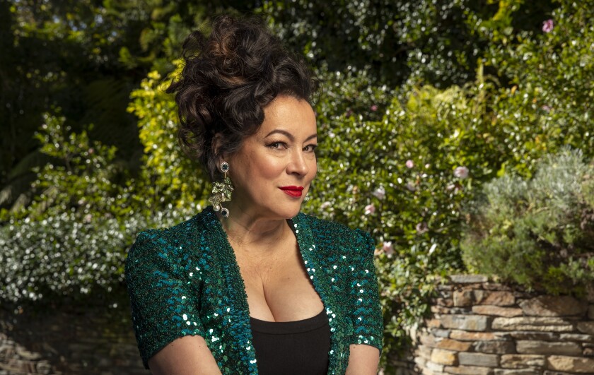 A portrait of Jennifer Tilly in a sparkly green top