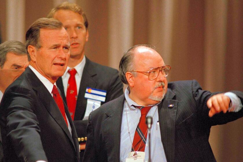 FILE - In this Aug. 17, 1988 file photo, Vice President George H.W. Bush, left, gets some advice from his media advisor, Roger Ailes, right, as they stand behind the podium at the Superdome in New Orleans, La., prior to the start of the Republican National Convention. Fox News said on Thursday, May 18, 2017, that Ailes has died. He was 77. (AP Photo/Ron Edmonds)