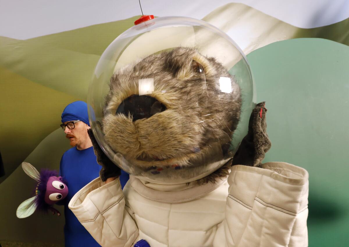 Gwen Hollander plays Astron-otter, the full-size otter dressed in a white astronaut suit. At left is Christian Anderson who plays Sy the Wide-Eyed Fly.