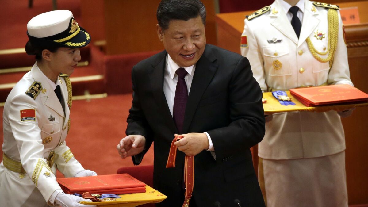 Chinese President Xi Jinping prepares to present a medallion during a conference marking 40 years of market reforms at the Great Hall of the People in Beijing on Dec. 18.