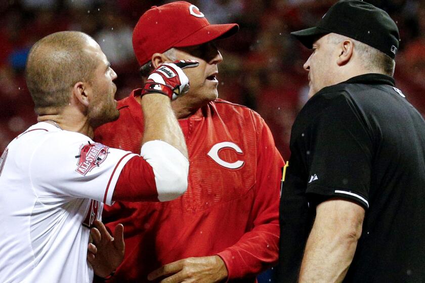 Reds first baseman Joey Votto, left, is separated from umpire Bill Welke, right, by Manager Bryan Price after Votto was ejected from the game on Wednesday night in Pittsburgh.