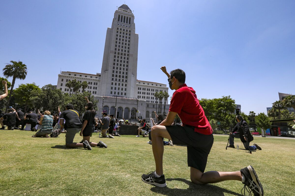 People take a knee during a George Floyd protest in front of L.A. City Hall.