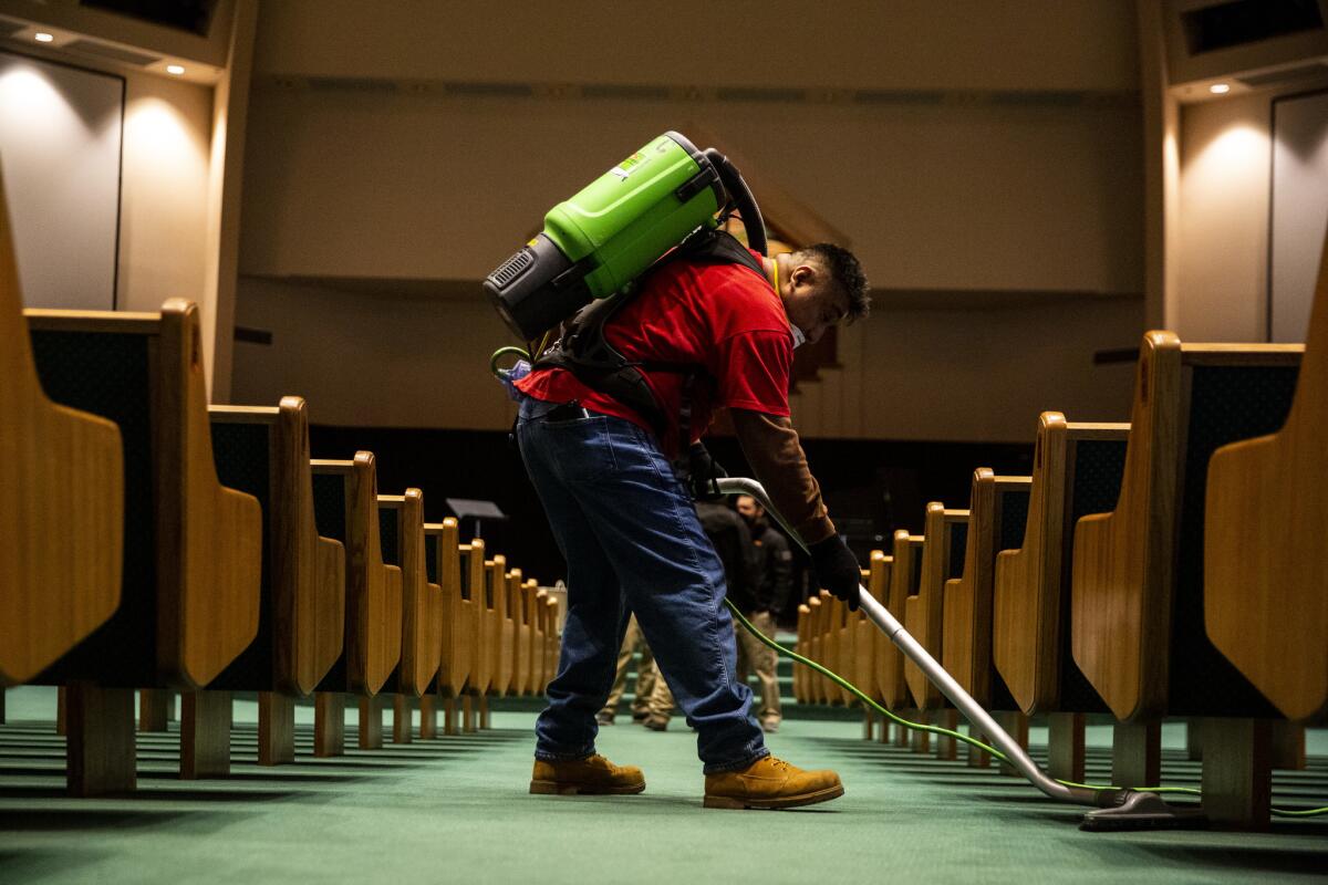 Servpro cleaner Johnny Velasquez of Yuba City vacuums between pews at the Paradise Alliance Church in Paradise. The church, barely touched by the Camp fire, plans to hold Christmas Eve services for the entire town of Paradise.