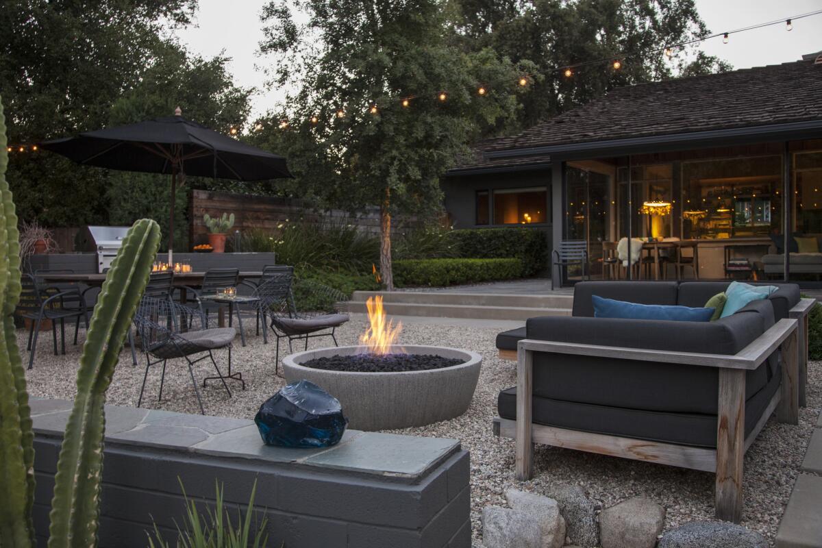 The outdoor living room's built-in grill and fire bowl make hosting alfresco gatherings convenient and comfortable.