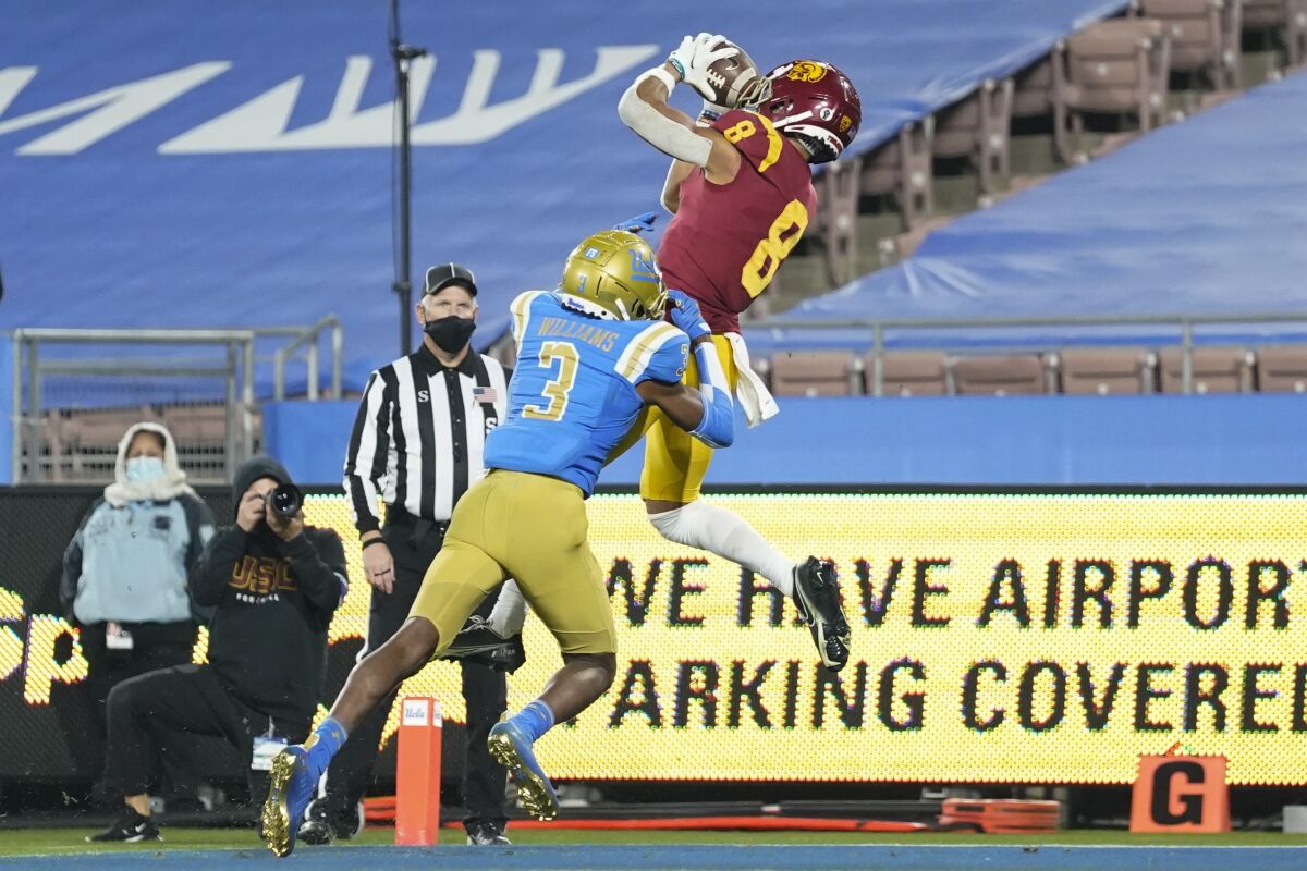USC's Amon-ra St. Brown catches the winning touchdown pass while defended by UCLA's Rayshad Williams on Dec. 12, 2020.
