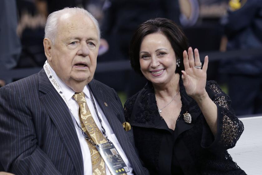 New Orleans Saints owner Tom Benson sits on the sideline with wife Gayle Benson before a game against the Green Bay Packers in October.