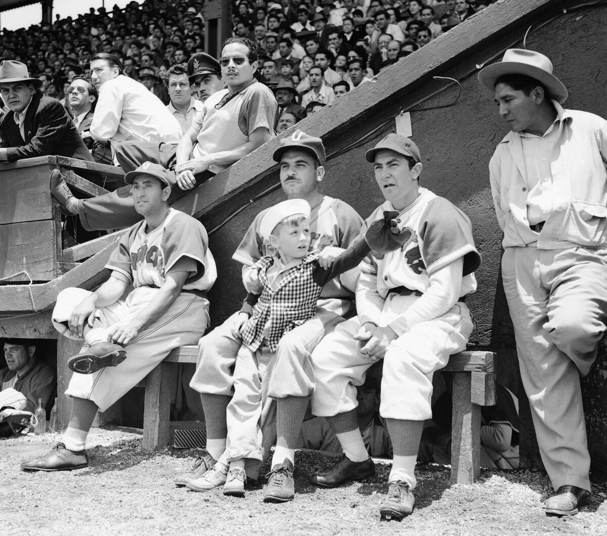 Jorge Pasquel, president of the Mexican Baseball League, is shown (center) in uniform on the bench of his Veracruz team.
