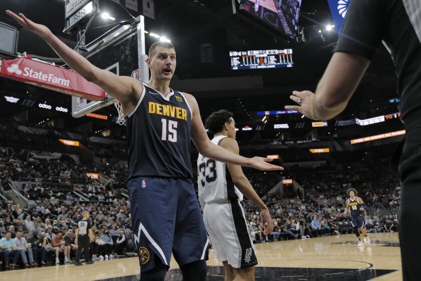 Denver Nuggets' Nikola Jokic (15) complains to a referee during the second half of an NBA basketball game against the San Antonio Spurs, Thursday, Dec. 9, 2021, in San Antonio. (AP Photo/Darren Abate)