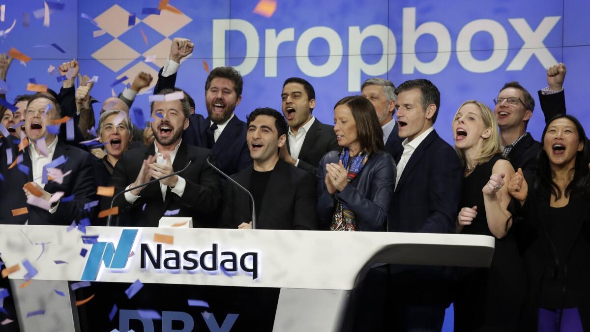 Dropbox executives, celebrating the company's IPO, ring the opening bell at the Nasdaq MarketSite in New York's Times Square.