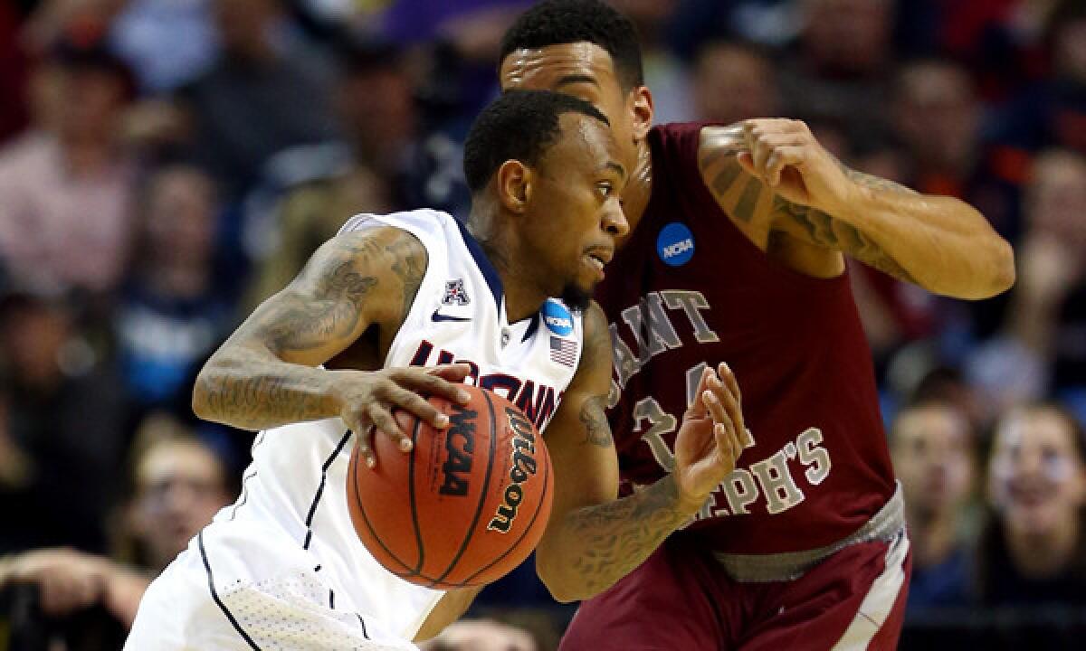 Connecticut's Ryan Boatright, left, drives past Saint Joseph's Chris Wilson during the Huskies' 89-81 overtime win in the second round of the NCAA tournament on Thursday.