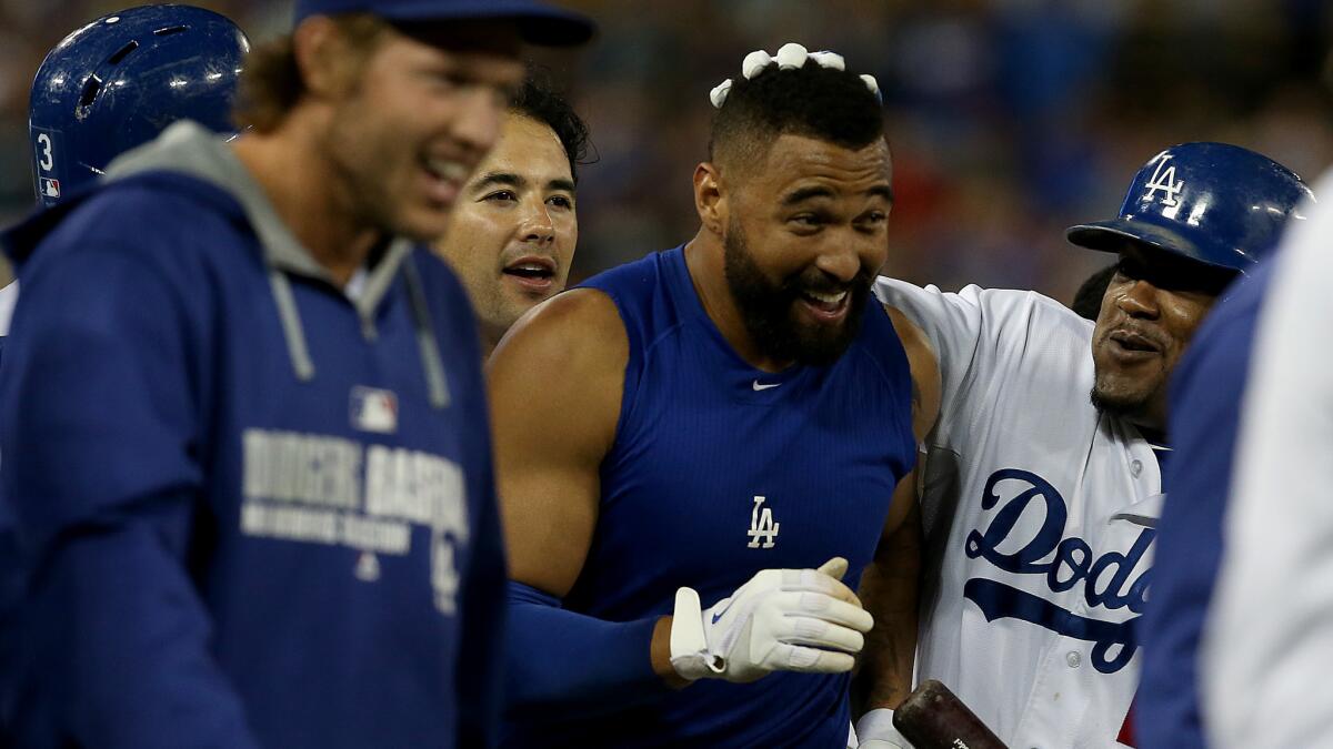 Dodgers right fielder Matt Kemp is congratulated by his teammates after driving in the winning run in the 10th inning of the team's 3-2 victory over the Atlanta Braves on Wednesday.