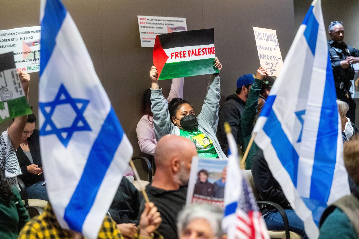 People hold blue and white flags and posters that say "Free Palestine."