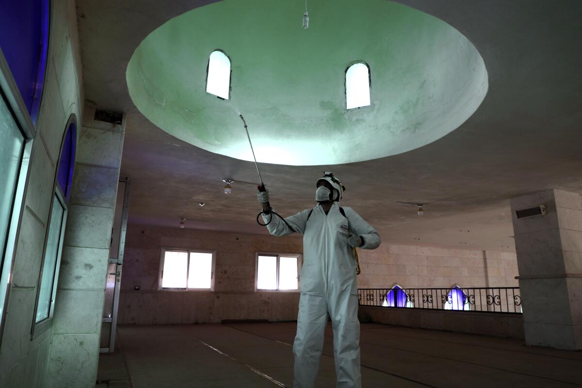 A member of the Syrian Civil Defense disinfects a mosque in Dana.