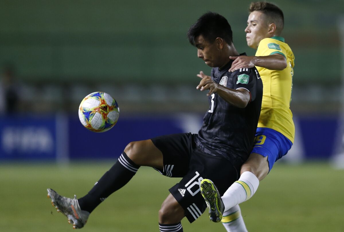Mexico's Efraín Álvarez, left, fights for the ball with Brazil's Pedro Lucas during the 2019 U-17 World Cup final.