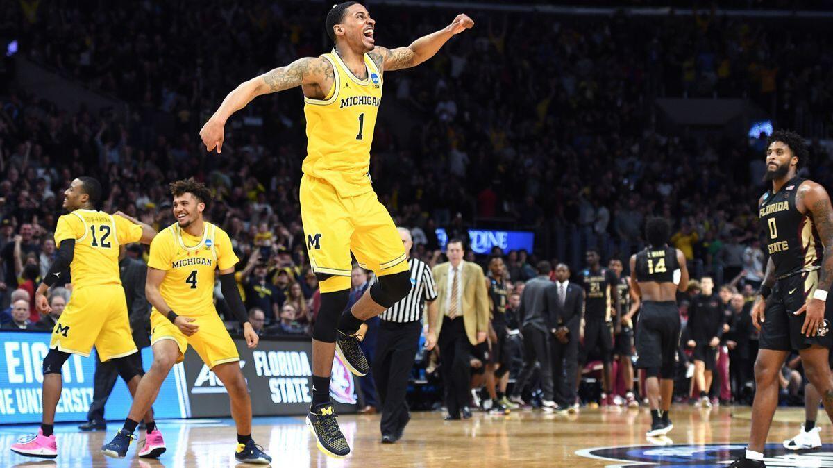Michigan's Charles Matthews, center, celebrates at the end of the game to defeat Florida State in the regional final of the NCAA tournament at the Staples Center Saturday.