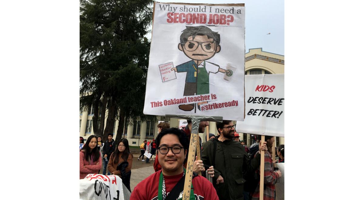 Cristopher Bautista, a ninth-grade teacher at Oakland Technical High School, participates in a one-day "sickout" wearing the Starbucks apron he dons during weekend shifts.