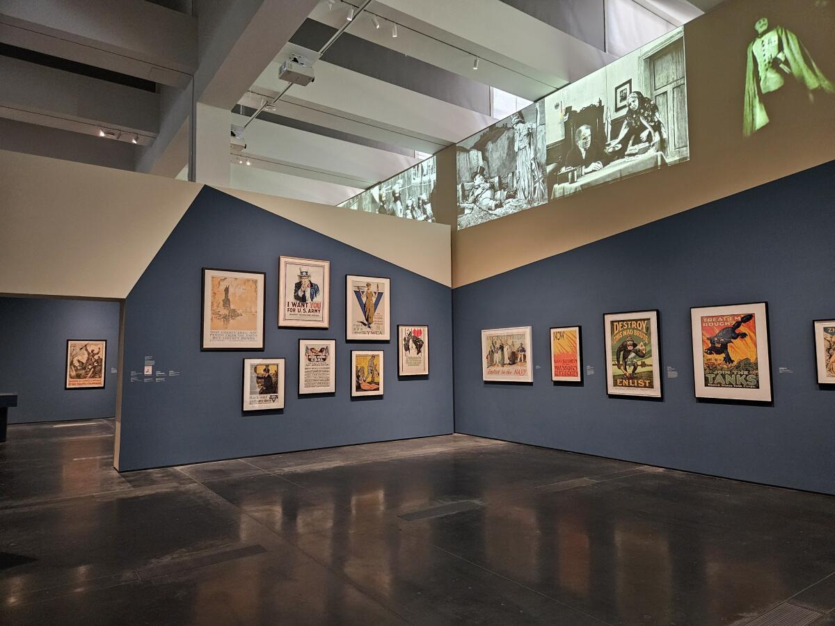 Installation view of posters and film clips in a museum exhibition.
