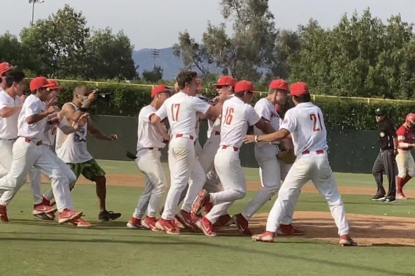 Harvard-Westlake players celebrate the pitching performance of freshman Bryce Rainer in 3-2 win over Orange Lutheran.