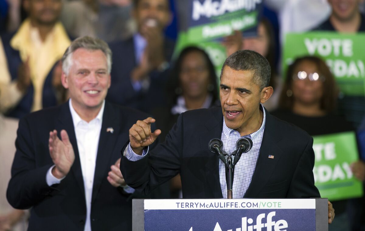 FILE - In this Nov. 3, 2013, file photo, President Barack Obama, right, as he speaks at a campaign rally with supporters for Virginia Democratic gubernatorial candidate Terry McAuliffe, left, at Washington Lee High School in Arlington, Va. Former President Obama will campaign with McAuliffe in the final stretch of the Virginia governor's race. McAuliffe's campaign announced that Obama will join him in Richmond on Oct. 23, 2021, to mobilize Virginians during early voting, which began weeks ago. AP Photo/Cliff Owen, File)