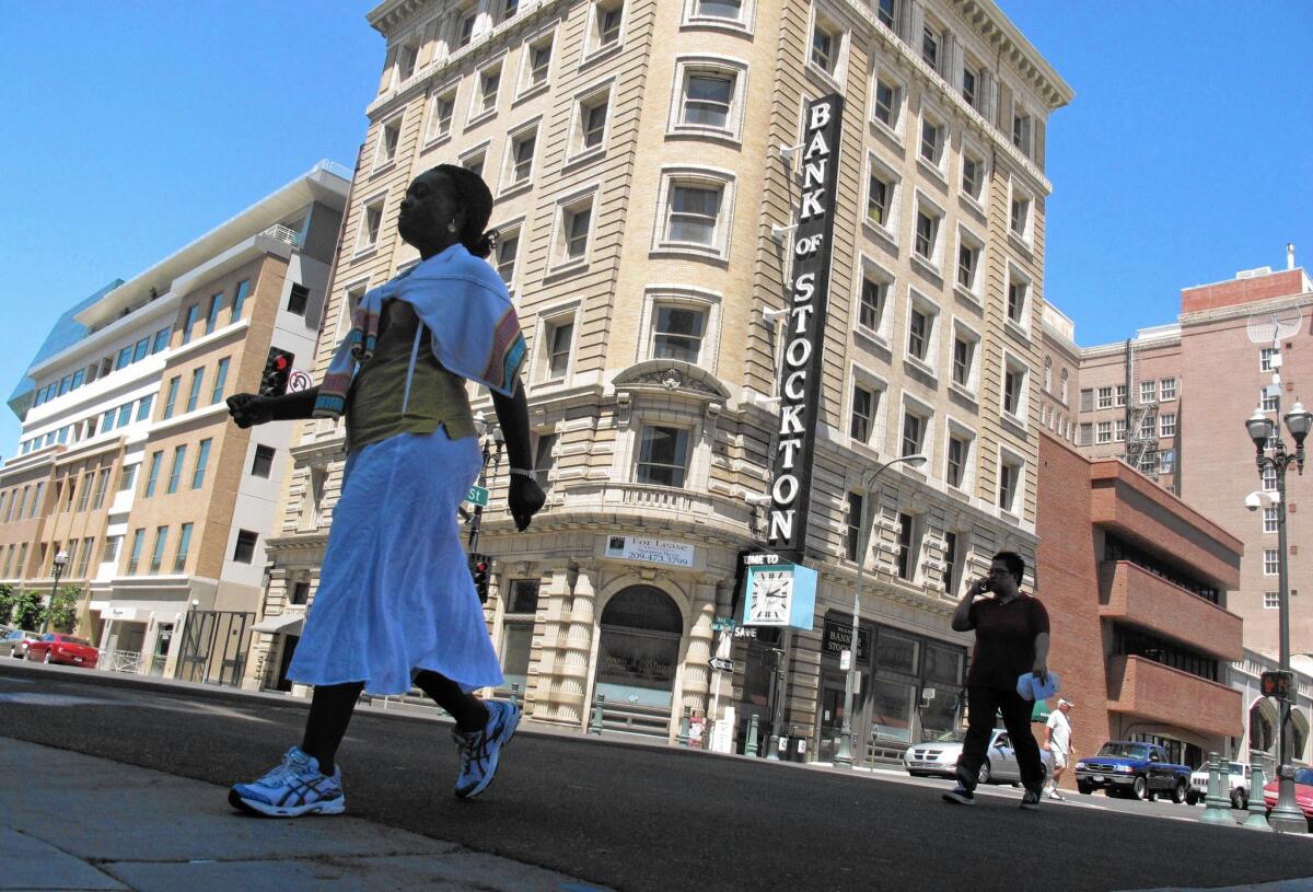 Pedestrians walk past the Bank of Stockton. A federal judge is expected to rule on the city's bankruptcy plan.